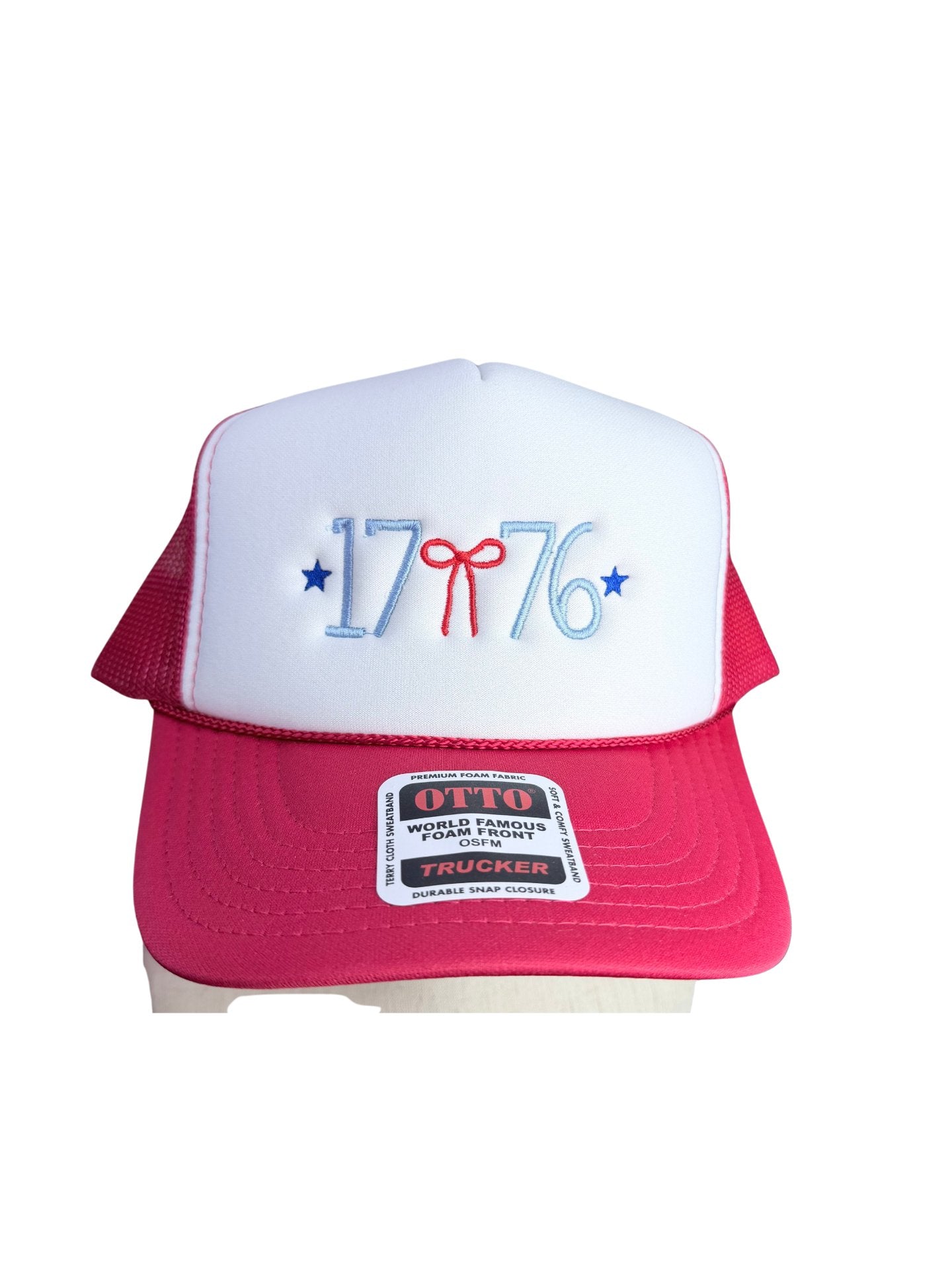 Front view of red and white Otto foam front trucker hat with 1776 embroidered in light blue thread, red bow, and blue stars on white foam pane