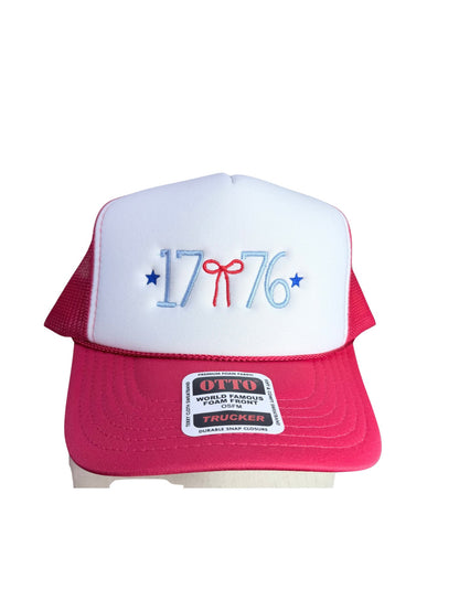 Front view of red and white Otto foam front trucker hat with 1776 embroidered in light blue thread, red bow, and blue stars on white foam pane